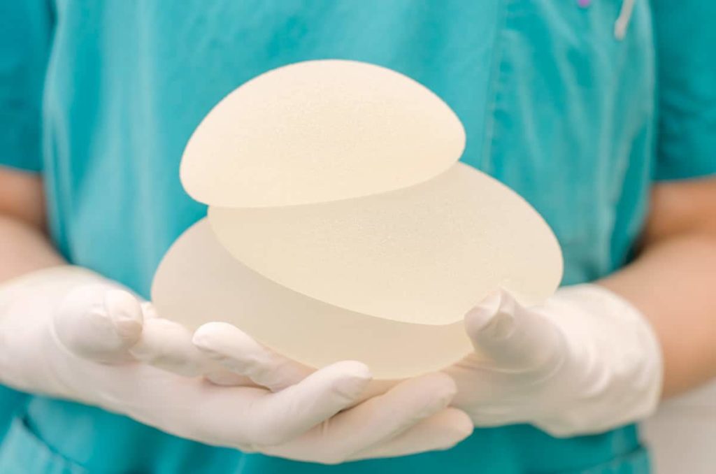 surgeon-holding-breast-implants